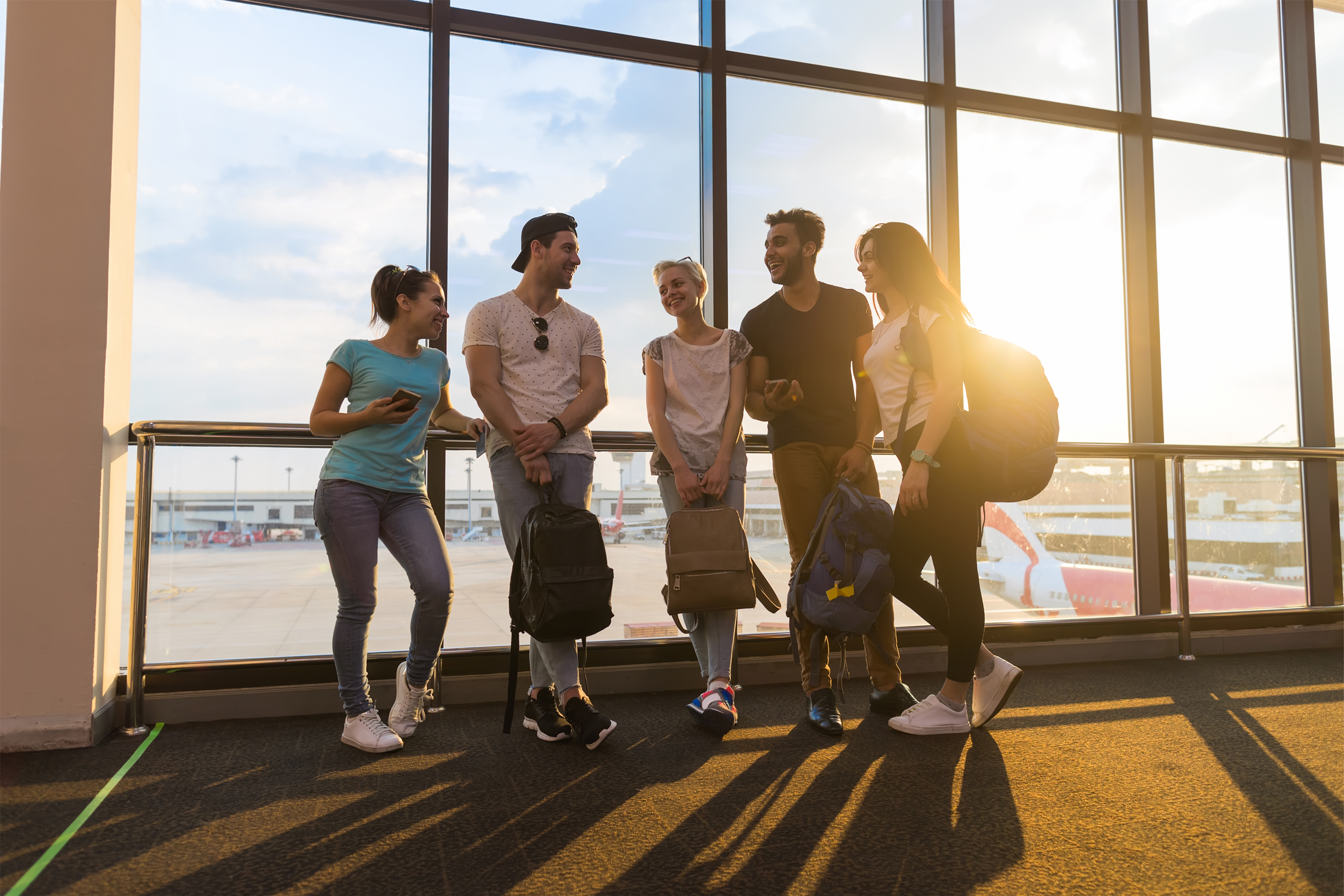 Giovani in partenza con trolley in aeroporto